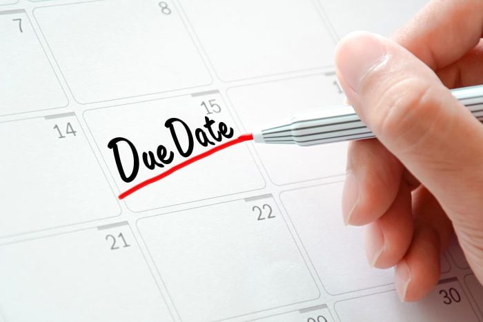 Hand writing the words "Due Date" on a calendar - Know why project due dates are set - myprojectlessons.com